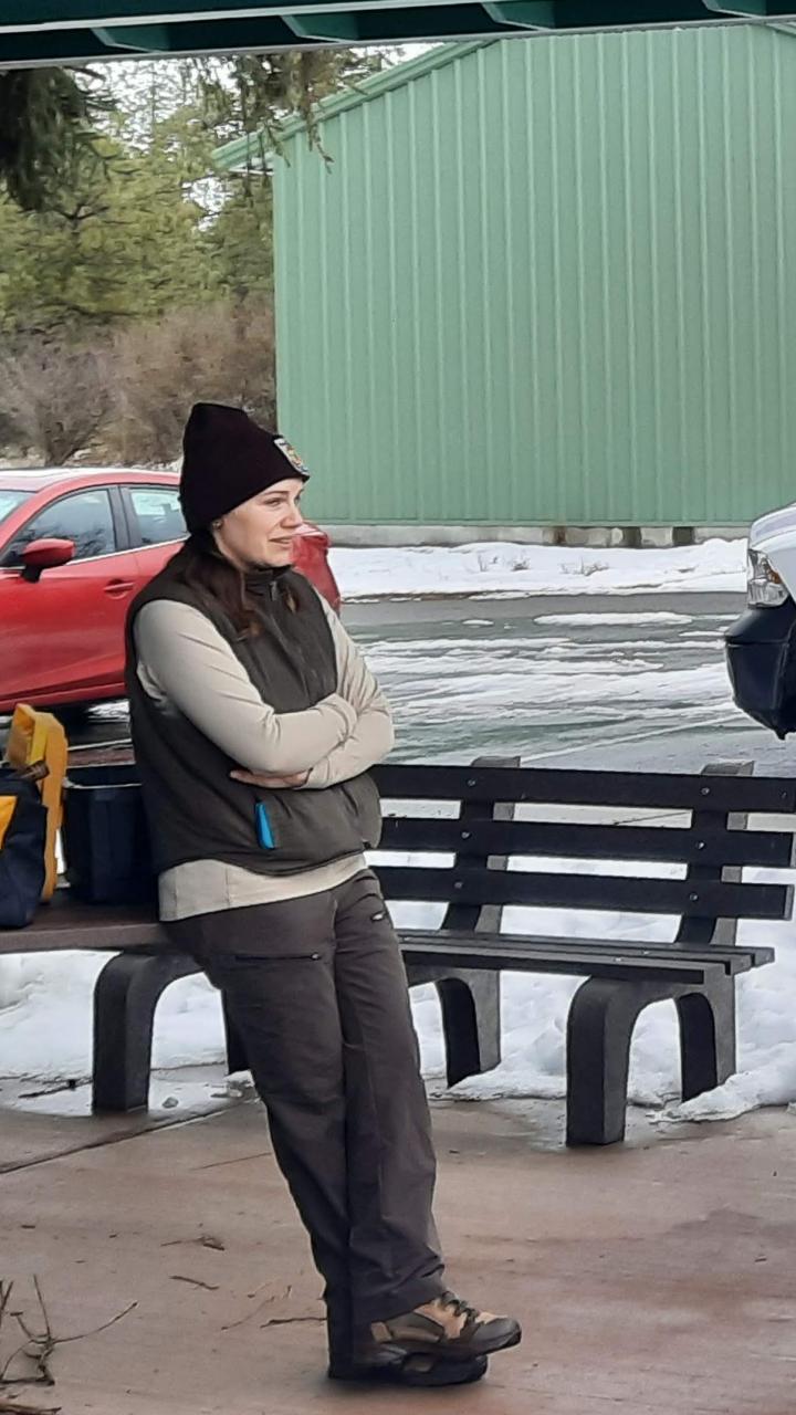 A biologist speaks with university students outside before a field assignment.
