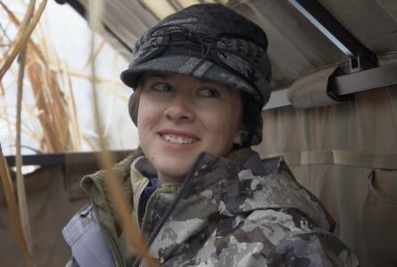 Close up of a young woman in camouflage smiling at the camera